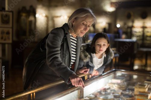 Cute interested preteen girl visiting museum of applied arts with grandmother, exploring ancient artworks .. © JackF