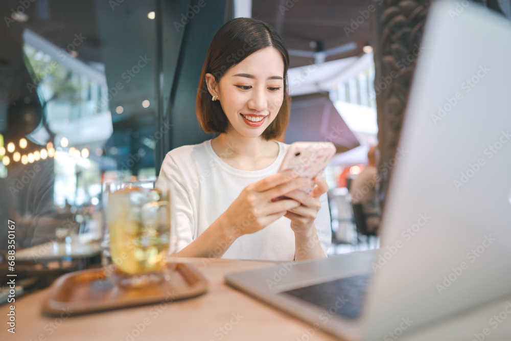 Business freelance asian woman using smartphone and laptop computer rest at cafe restaurant lifestyle