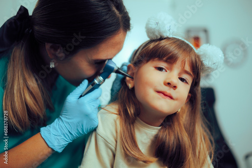 Doctor Holding Otoscope a Doing a Pediatric Ear Examination. Little kid having problem with otitis after a flu episode   