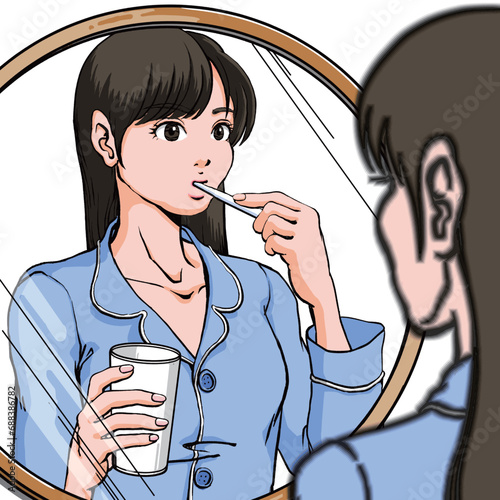 洗面台前に立ち歯磨きするパジャマ姿の若い女性_コップ有り