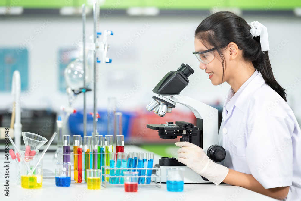 Fototapeta premium Asian female scientist medical presenter Currently doing research on cell chemistry and viral diseases. in biology laboratories of universities in government organizations to produce medicines
