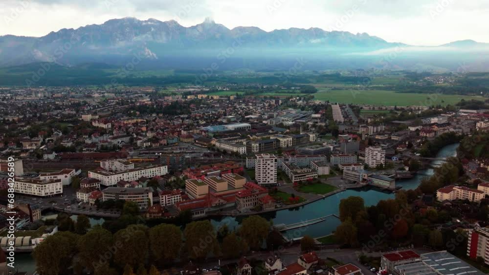 Aerial cinematic drone early cloudy morning Thun Switzerland Swiss lake river downtown city village Bern Interlocken view of Stockhorn Stockhornkette sunrise forward pan up reveal movement