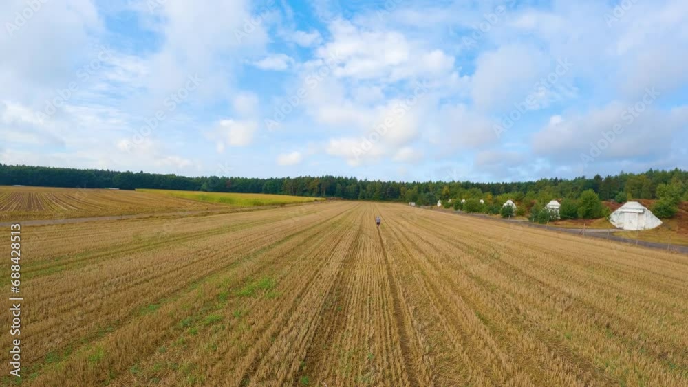 Following A Man Running In The Field In The Countryside. - aerial shot Following A Man Running In The Field In The Countryside. - aerial shot