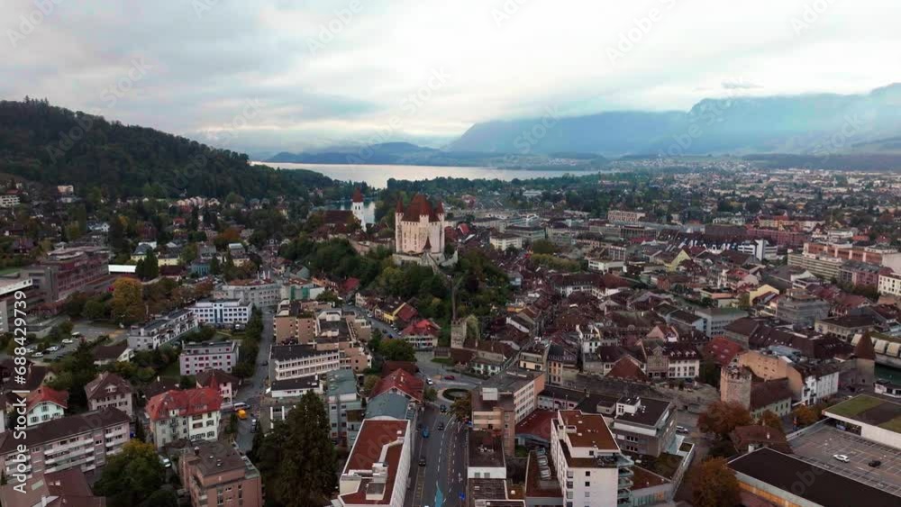 Aerial cinematic drone downtown  Thun Switzerland lake cars Swiss village city downtown stunning Thun Castle Dukes of Zährigen Interlocken Bern Jungfrau cloudy sunrise sunset backward slowly  movement