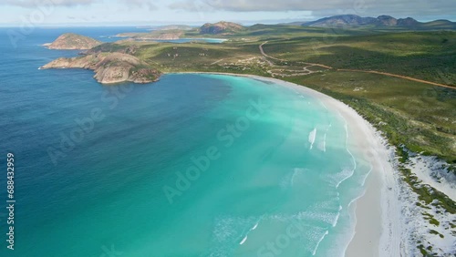 Aerial view of a 4WD car driving in the beach, waves - Lucky Bay, Australia - dolly, drone shot photo