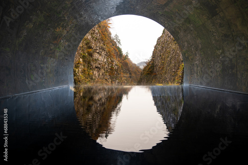 Kiyotsu Gorge Tunnel of Light with water reflection and forest mountain landscape view famous tourist spot in Autumn season at Tokamachi, Niigata, Japan