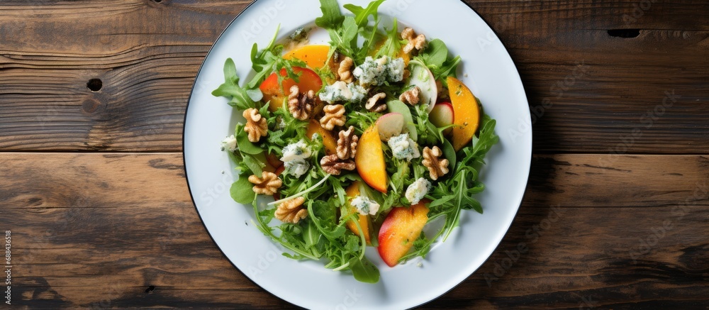 Winter salad with persimmon, spinach, arugula, lettuce, blue cheese, walnuts on white plate, view from above on old wooden boards. Winter salad with persimmon, spinach, arugula, lettuce, blue cheese, walnuts on white plate, view from above on old wooden boards.