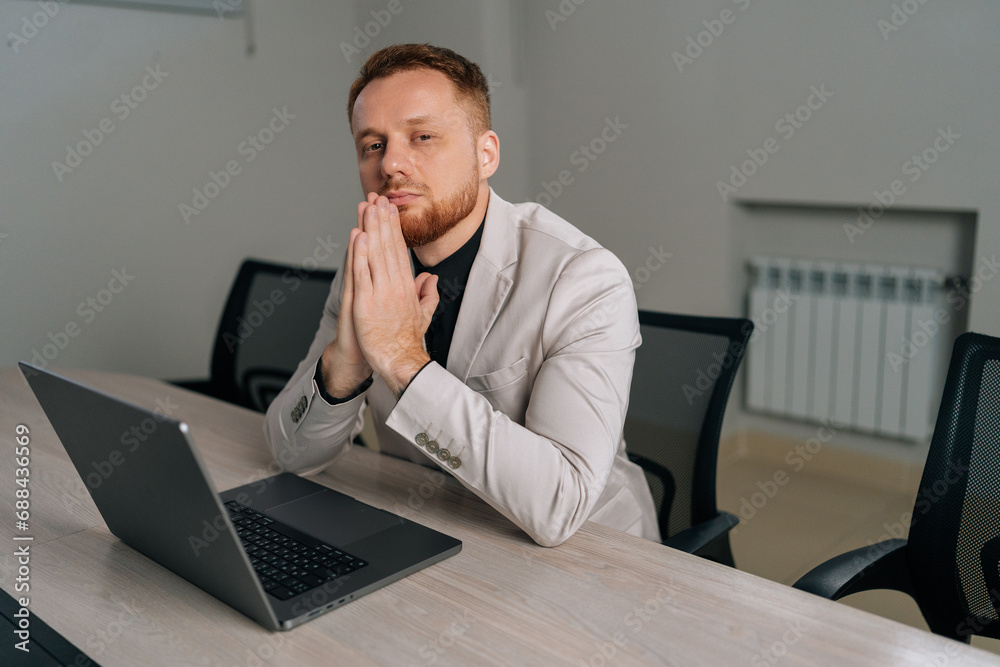 Portrait of pensive businessman sitting at desk with clasped palms thinking search problem solution, collect thoughts together, organize emotional state before important meeting, looking at camera. Portrait of pensive businessman sitting at desk with clasped palms thinking search problem solution, collect thoughts together, organize emotional state before important meeting, looking at camera.