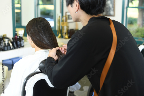 女性客のヘアスタイリングをする男性美容師