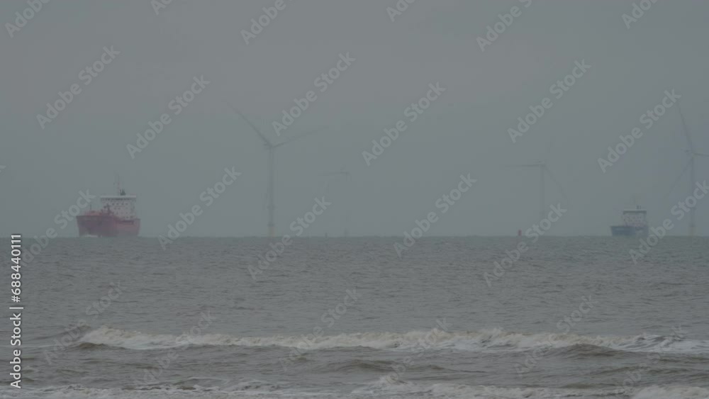 Ship heading in to the Port of Liverpool on windy and cloudy day with wind turbines in background Ship heading in to the Port of Liverpool on windy and cloudy day with wind turbines in background