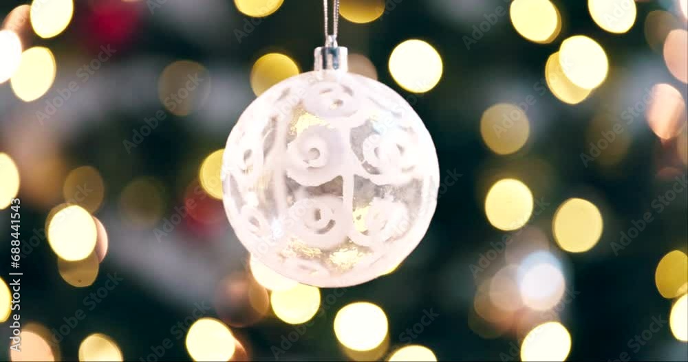 Ball, new year and Christmas with festive lights hanging on tree with bokeh background. Closeup of ornament, decoration or bauble in December season for celebration or holiday weekend at home