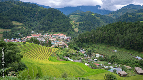 Landscape with green and yellow terraced rice fields and a river in the highlands of North-Vietnam, Yen Bai province	 photo