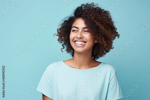 Smiling Woman in White Shirt Standing on Blue Background © People