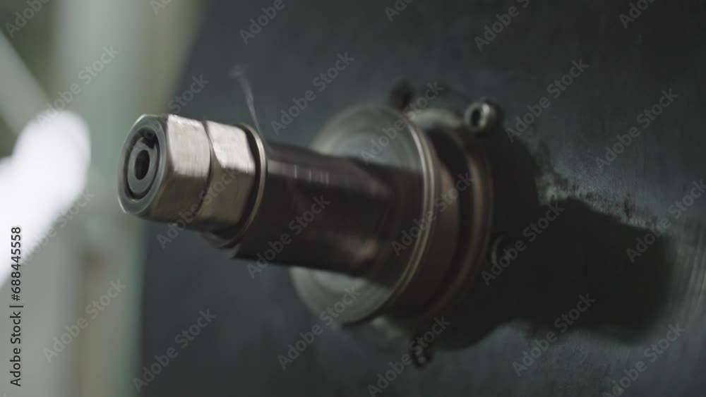 Wheel on machine in factory spin around. Never stop process of wheel hub in industrial plant - close up. Wheel on machine in factory spin around. Never stop process of wheel hub in industrial plant - close up.