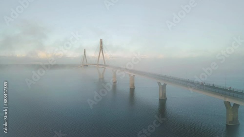 Rising aerial view of Replot Bridge, Finland, on misty morning photo