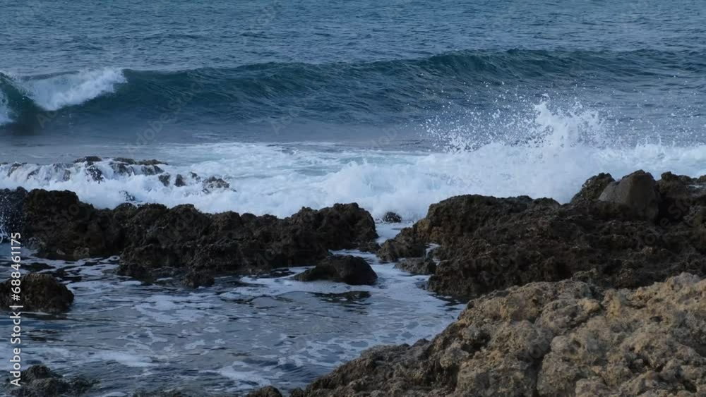 Ocean waves rocks slow motion. Huge foaming waves roll on the stone shore. Dark blue turquoise sea water. The concept of the elements, windy weather, tropical climate. Fascinating movement of water. Ocean waves rocks slow motion. Huge foaming waves roll on the stone shore. Dark blue turquoise sea water. The concept of the elements, windy weather, tropical climate. Fascinating movement of water.