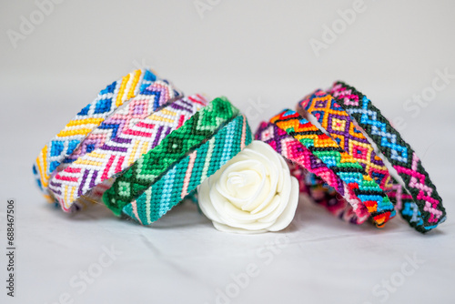 Pile de bracelets brésiliens avec une rose blanche