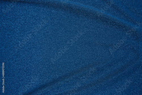 Trendy 80s, 90s, 2000s Background of draped dark blue fabric with silver lurex thread. Beautiful fashionable shiny fabric with a shiny thread for making clothes. Textile background texture.