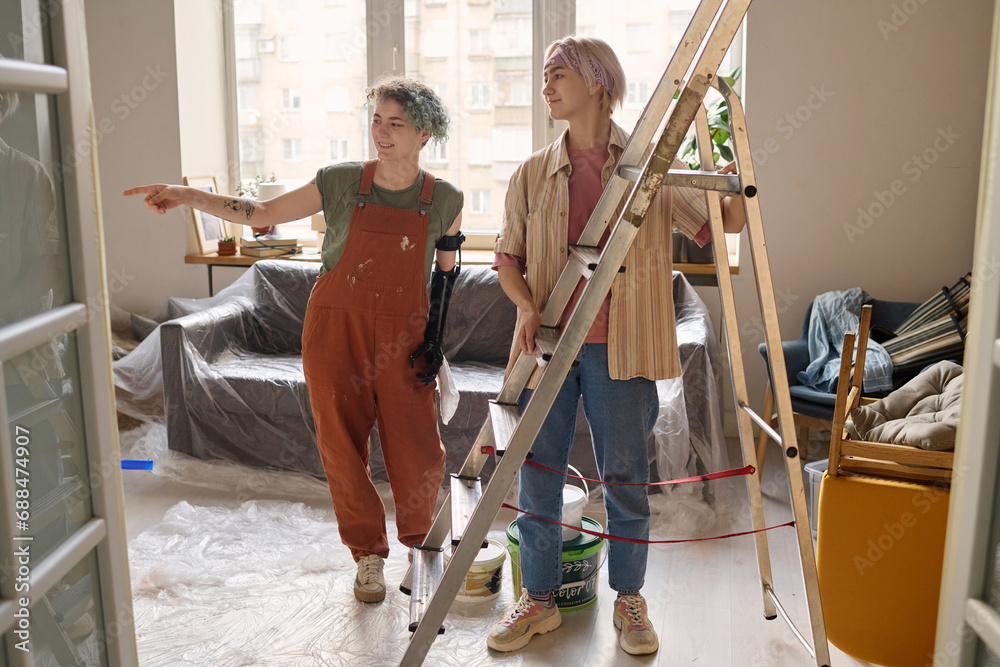 Obraz premium Two girls discussing the moment of future repair in their new apartment