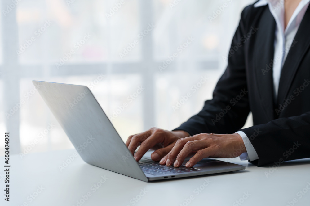 Close up. Asian businessman working with laptop computer at modern office Businessman in black suit working and typing on laptop keyboard Internet online at the desk in the office. Close up. Asian businessman working with laptop computer at modern office Businessman in black suit working and typing on laptop keyboard Internet online at the desk in the office.