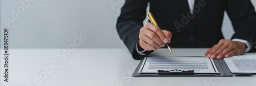 Fotografia Businessman holding a pen to sign a contract, making a detailed agreement, business contract for finance, real estate, insurance, taxes and signing an official document