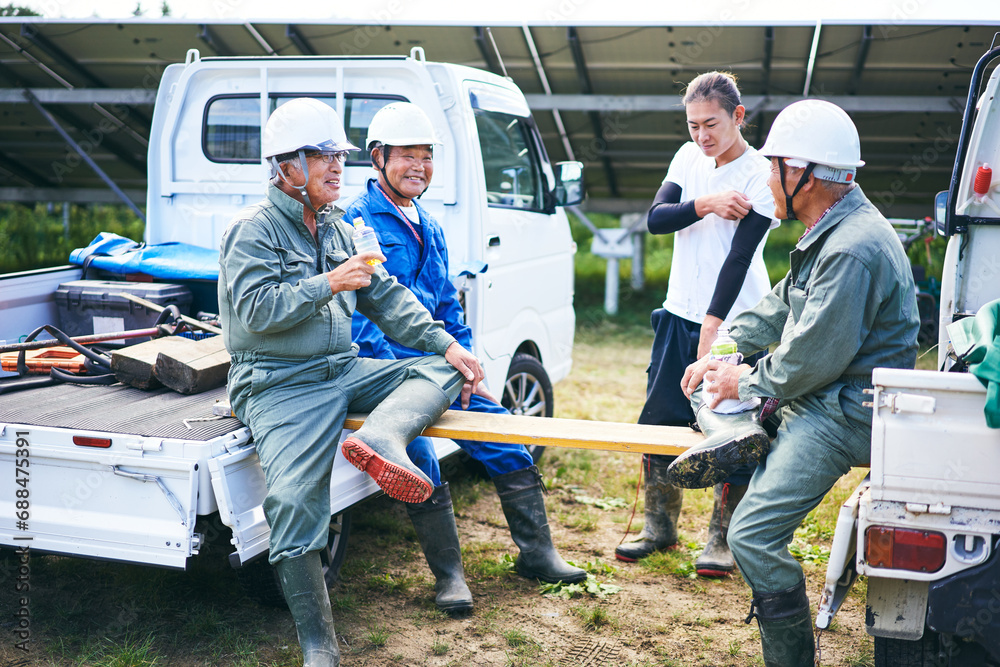 仕事の休憩中に談笑する日本人の男性たち 仕事の休憩中に談笑する日本人の男性たち