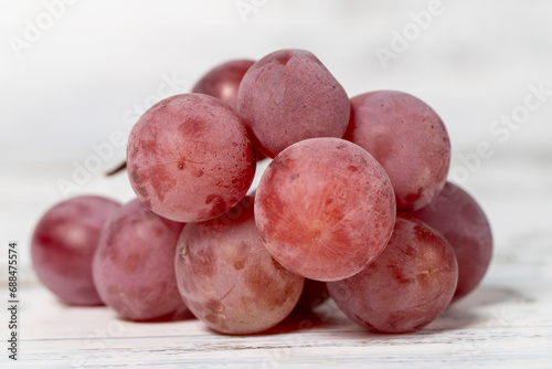 Fresh purple grapes on a white wooden background. Organic agricultural products. Delicious bunch of grapes