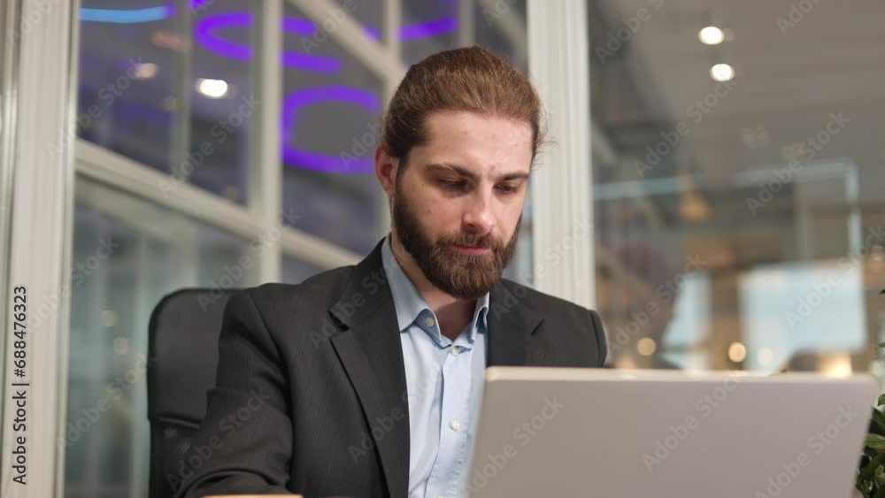 Focused middle-aged businessman opening his modern gadget during hard working day in office. Stylish person sitting at desk in formal suit improving his management with help of digital technology. Focused middle-aged businessman opening his modern gadget during hard working day in office. Stylish person sitting at desk in formal suit improving his management with help of digital technology.