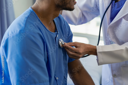 Quadro em tela A doctor uses a stethoscope to check the heartbeat of his patient
