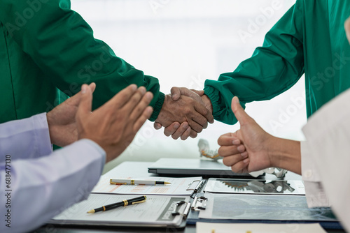 Researchers with medical experience shaking hands after successful medical conference, dedicated to health care doctors, medical nurses after successful work in hospitals.
