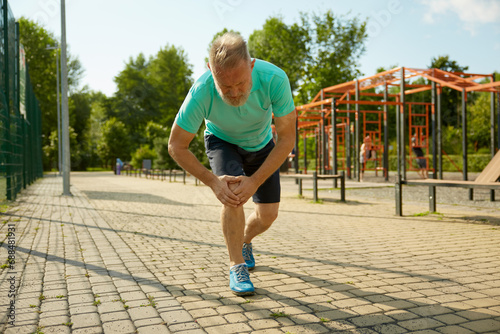 Photography Senior sportsman suffering with knee having injury during workout
