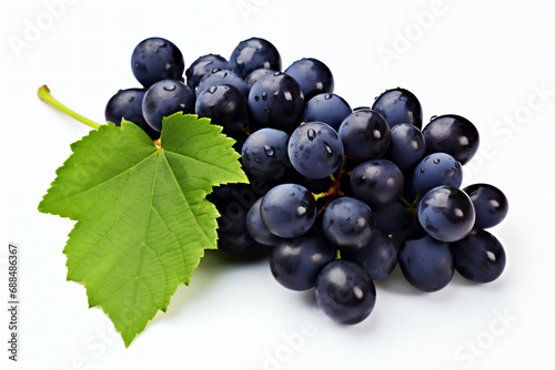 Bunch of ripe black grapes with green leaf isolated on white background