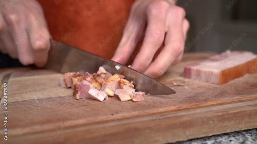 Person Cutting Bacon In Dices With A Knife On A Chopping Board. - close up shot Person Cutting Bacon In Dices With A Knife On A Chopping Board. - close up shot