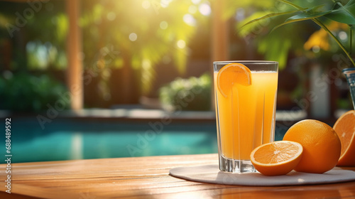 A glass of orange juice on the background of a swimming pool