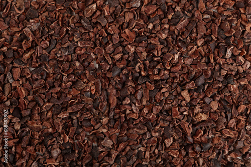 Bild auf Leinwand Crunchy pieces of peeled, crushed and lightly roasted cocoa beans with pleasant chocolate bitterness, close-up