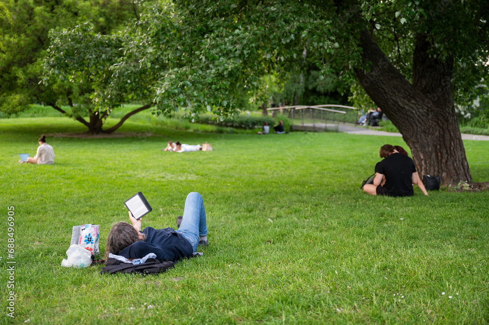 People resting and working on the lawn in the park People resting and working on the lawn in the park