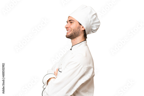 Young handsome chef man over isolated background in lateral position photo
