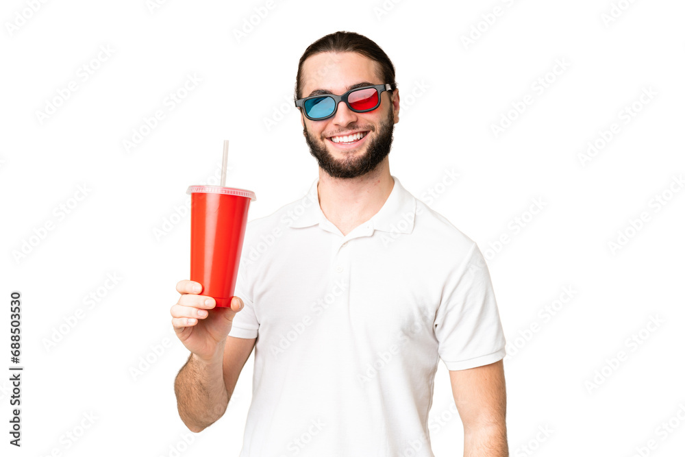 Young handsome man holding soda while watching a 3D movie over isolated chroma key background smiling a lot Young handsome man holding soda while watching a 3D movie over isolated chroma key background smiling a lot