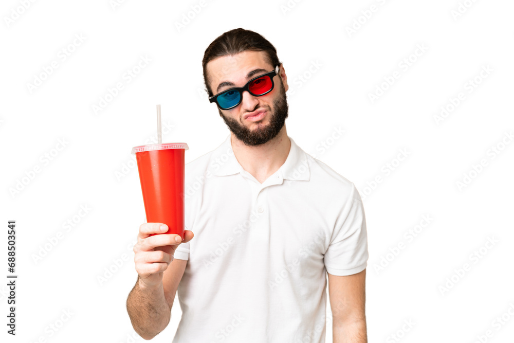 Young handsome man holding soda while watching a 3D movie over isolated chroma key background with sad expression Young handsome man holding soda while watching a 3D movie over isolated chroma key background with sad expression