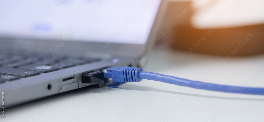 close up on laptop port interface with blue an cable connected to transfer bandwidth and usage internet data to global network for internet technology transmission service concept - obrazy, fototapety, plakaty 