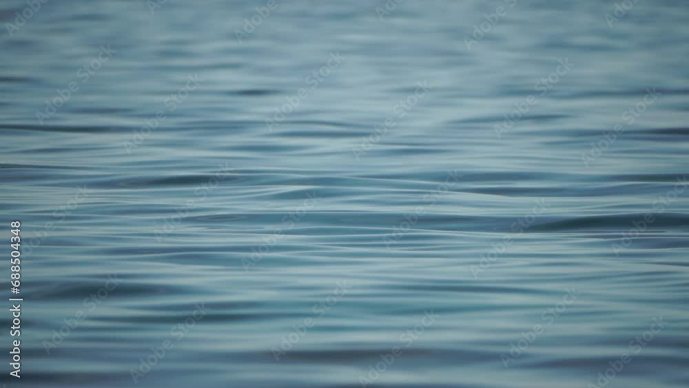 Abstract sea summer ocean sunset nature background. Small waves on water surface in motion blur with golden bokeh lights from sun. Holiday, vacation and recreational concept. Slow motion Abstract sea summer ocean sunset nature background. Small waves on water surface in motion blur with golden bokeh lights from sun. Holiday, vacation and recreational concept. Slow motion