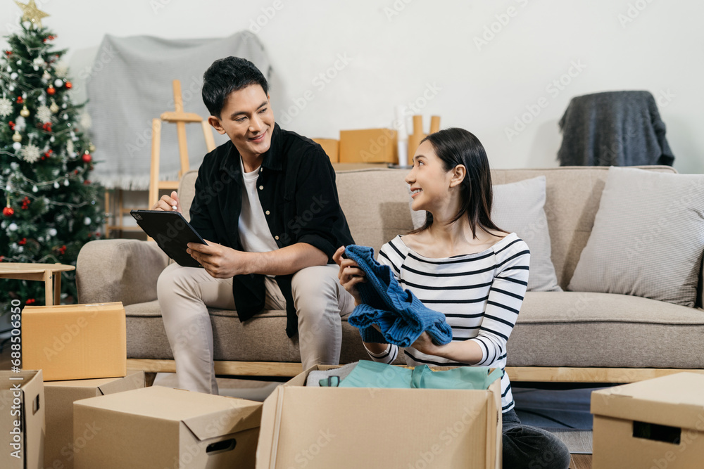 Young couple relaxing sitting on the floor around cardboard boxes at home, smiling happy moving to a new house. Young couple relaxing sitting on the floor around cardboard boxes at home, smiling happy moving to a new house.