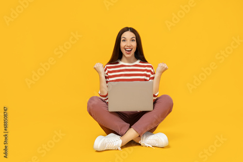 Happy girl with a cardboard box, a parcel, on a yellow background.