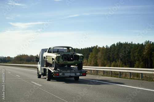 Recover a Retro Car After an Accident. A Project to Restore a Classic Car with the Help of a Tow Truck. A Vintage Car Damaged by a Collision on the Highway.