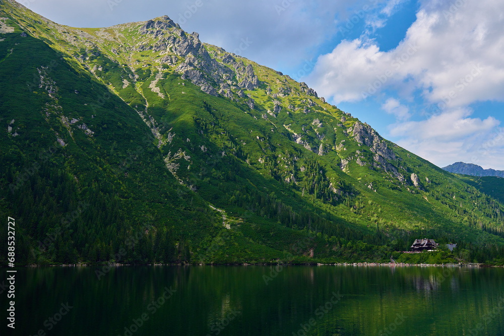 Amazing view on mountains range near beautiful lake at summer day. Tatra National Park in Poland. Panoramic view on Morskie Oko or Sea Eye lake in Five lakes valley Amazing view on mountains range near beautiful lake at summer day. Tatra National Park in Poland. Panoramic view on Morskie Oko or Sea Eye lake in Five lakes valley