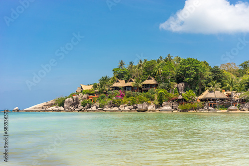 Fototapeta Naklejka Na Ścianę i Meble -  Picturesque seascape with resort on shore in lush greenery and rocks. Calm sunny sandy tropical place on exotic Koh Tao island in Thailand