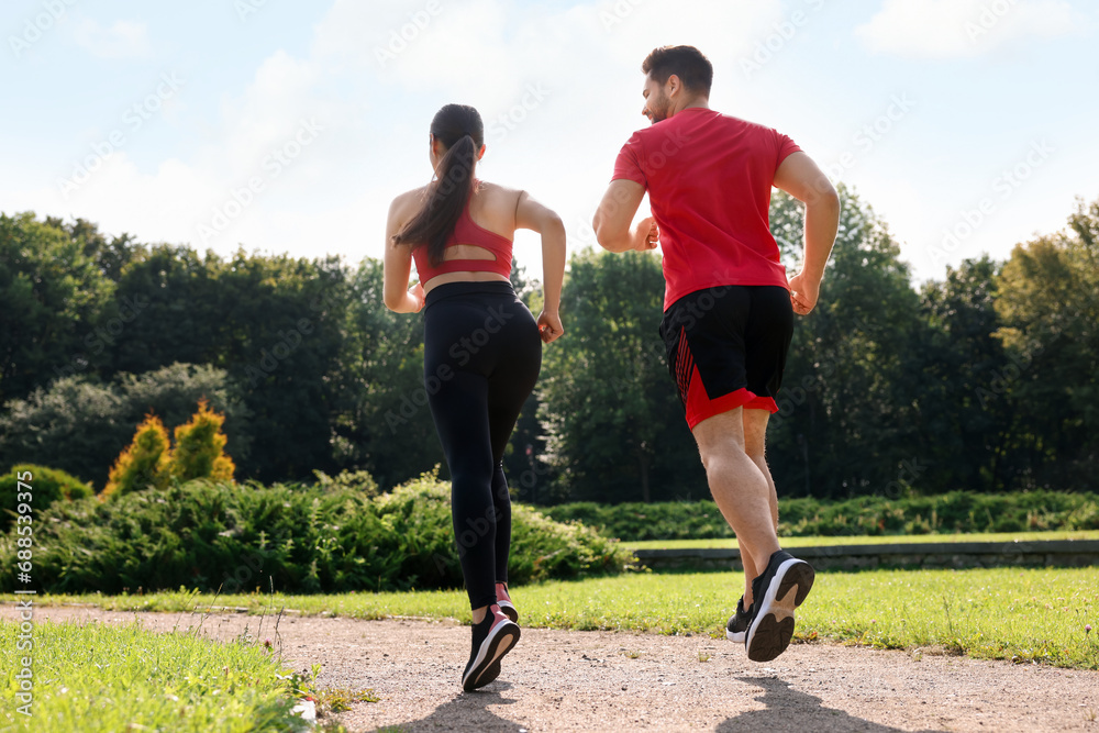 Healthy lifestyle. Couple running in park on sunny day, low angle view