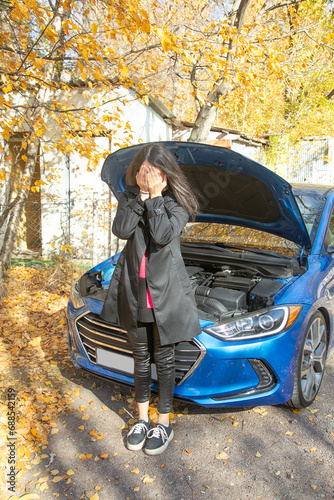 Upset and tired woman driver with her car.