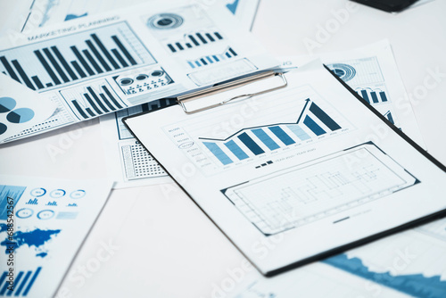 Piles of business intelligence paper or BI financial report and financial data visualization on paperwork for business analytic marketing and strategic planning at office desk. Prudent
