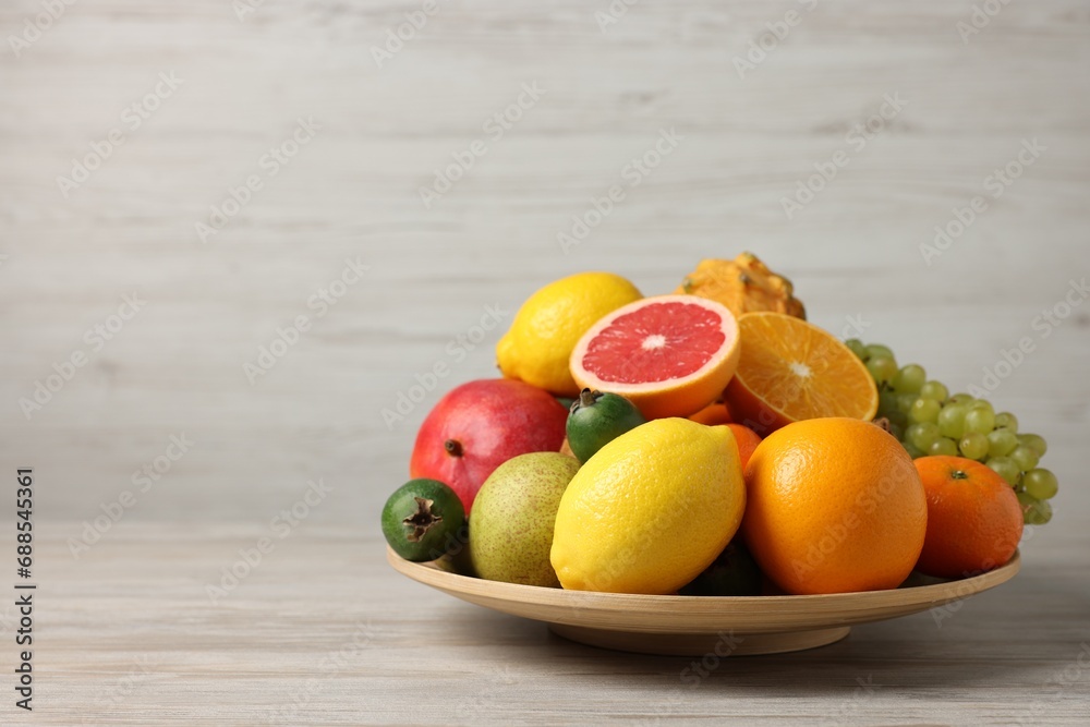 Different ripe fruits on light wooden table, space for text Different ripe fruits on light wooden table, space for text
